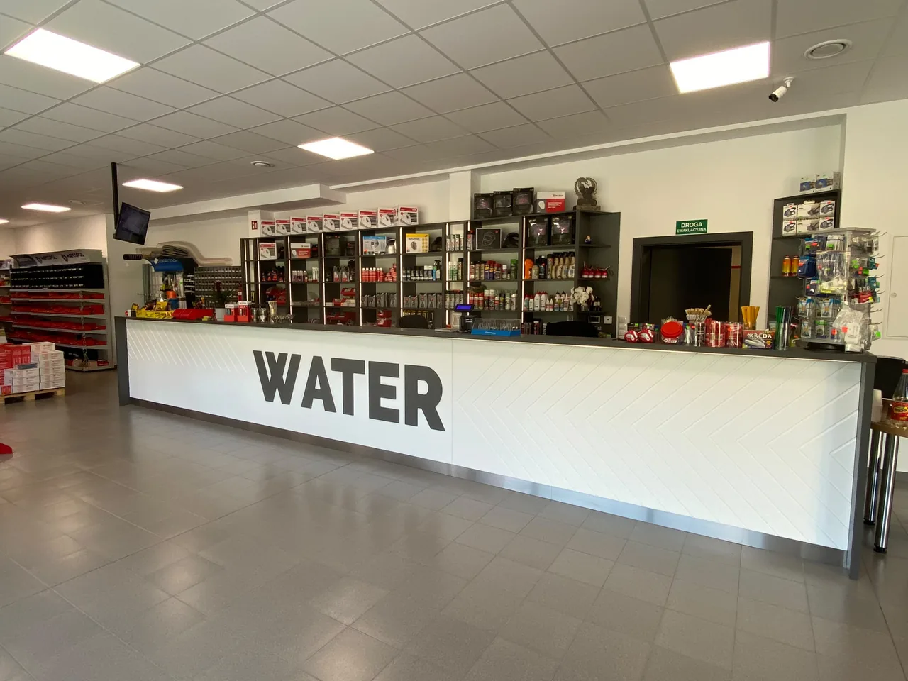 Lada sklepu WATER w Kłobucku z alejką pełną narzędzi w tle